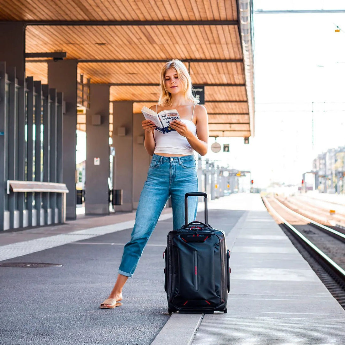 Mujer con maleta Samsonite Ecodiver en estación de tren